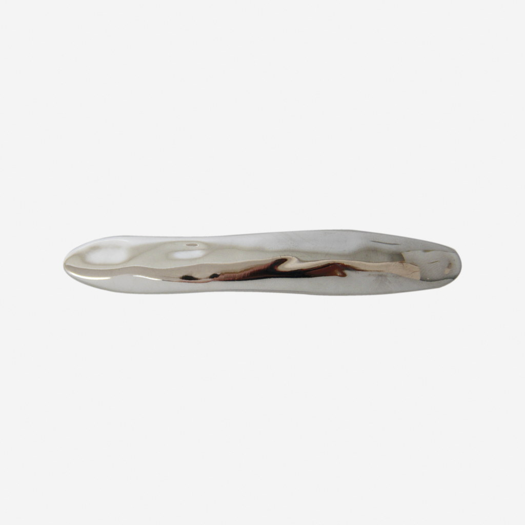 Silver hair clip with an organic shape on a white background