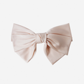 Large blush hair bow on an off white background