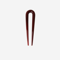 Small resin burgundy hairpin on an off white background