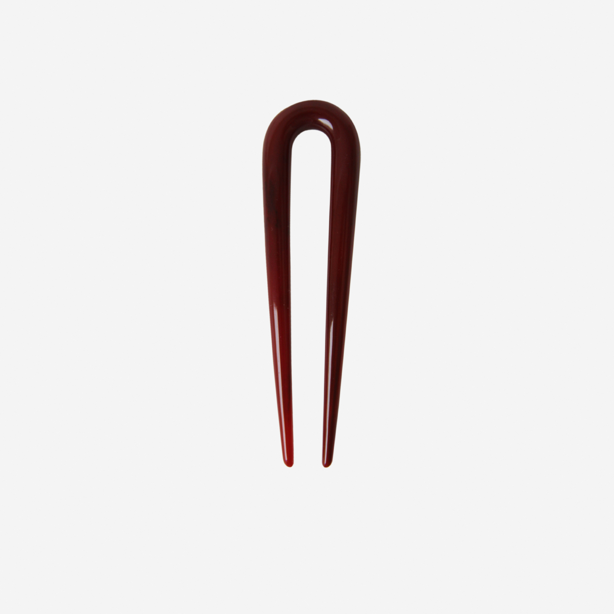 Small resin burgundy hairpin on an off white background