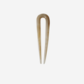 Small resin beige hairpin on an off white background