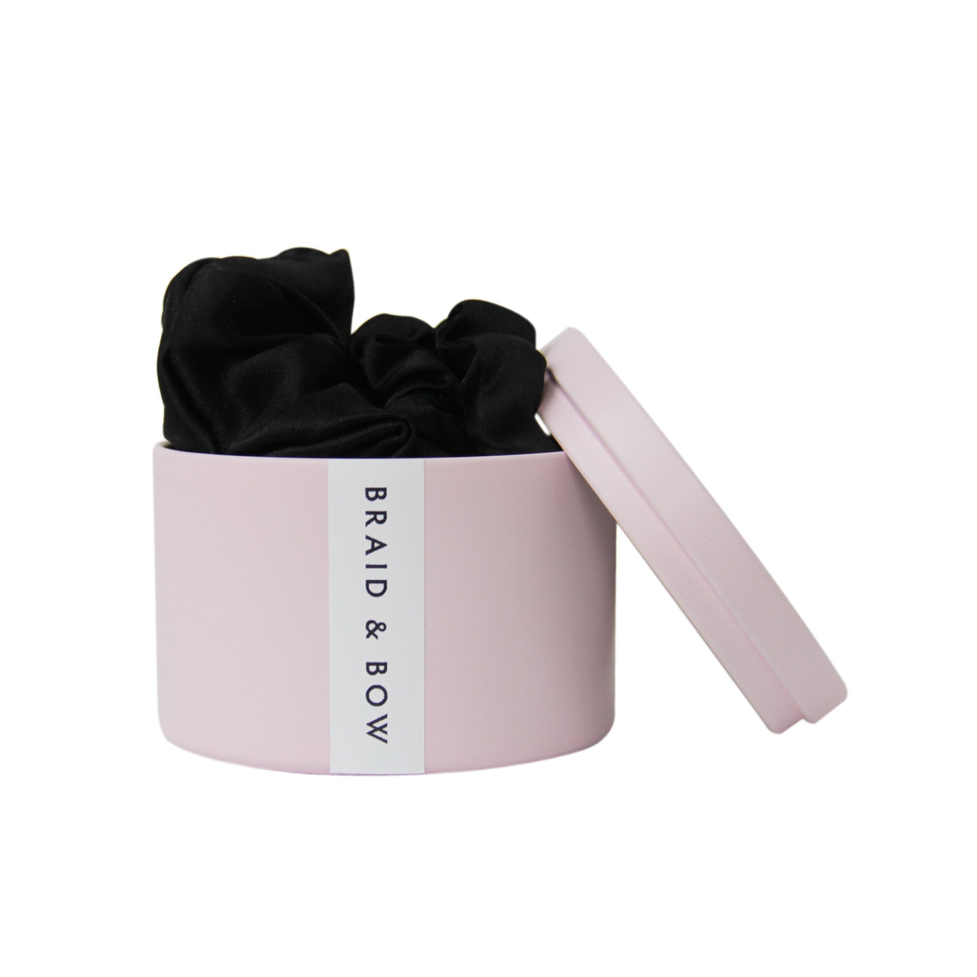Pink Braid & Bow tin with three black silk scrunches on a white background