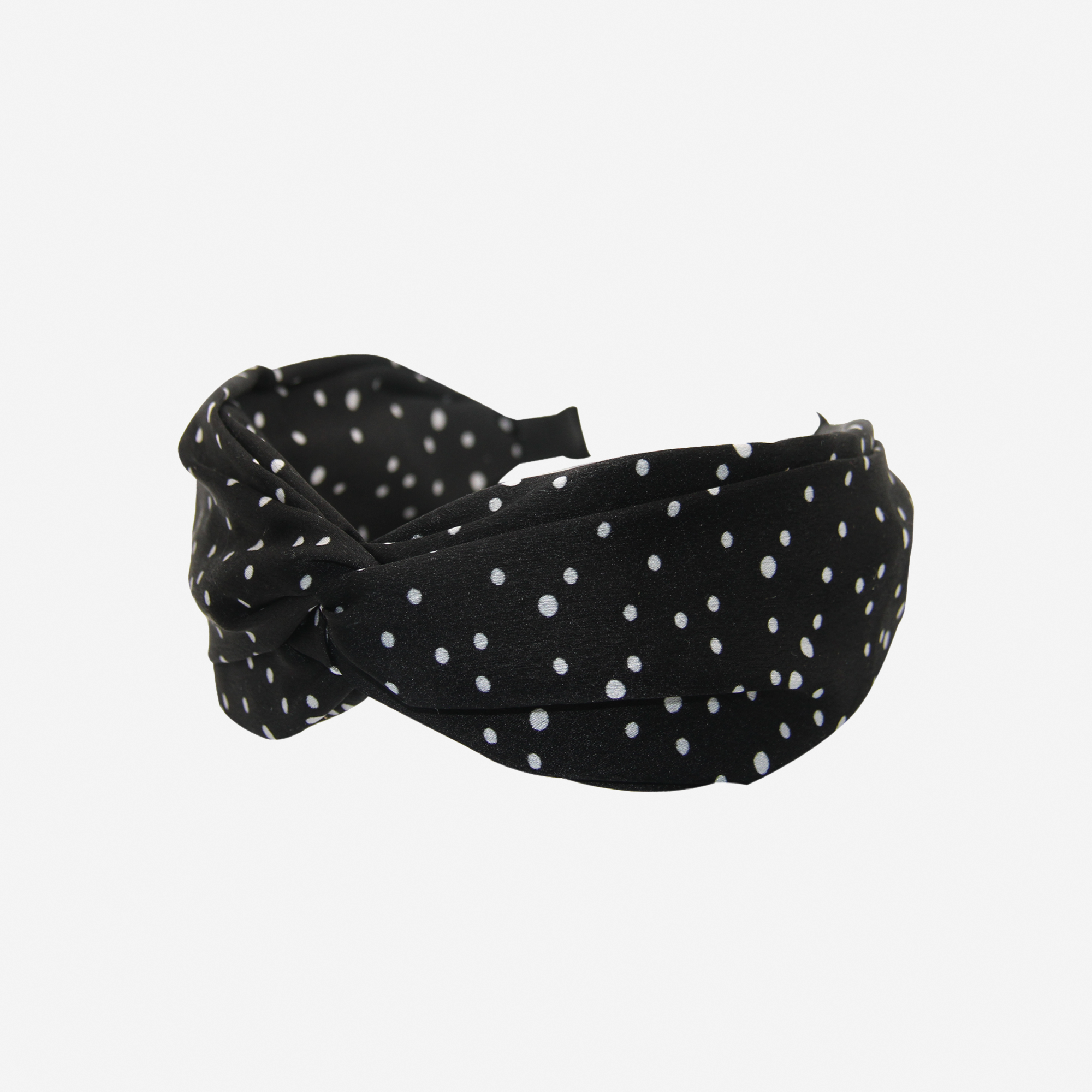 Black headband with white polka dots on an off white background