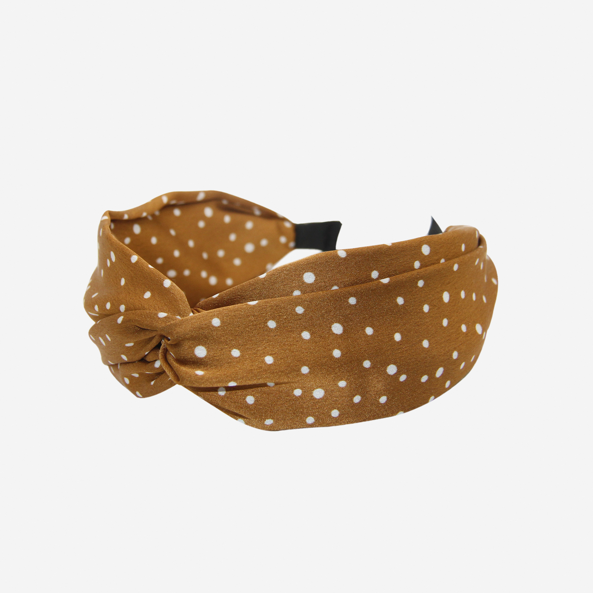 Bronze headband with white polka dots on an off white background