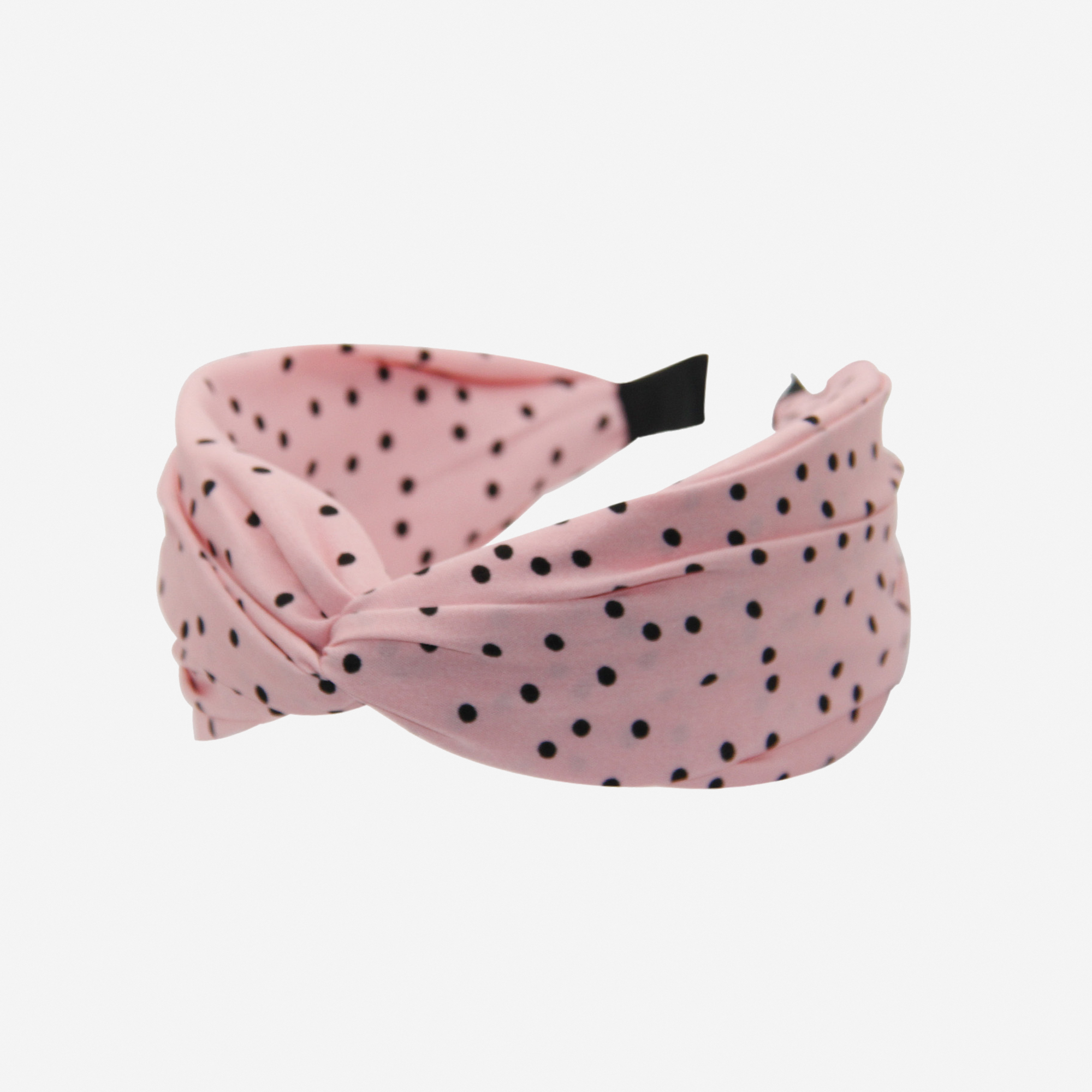 Pink headband with black polka dots on an off white background