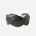 Woven black raffia headband on an off white background
