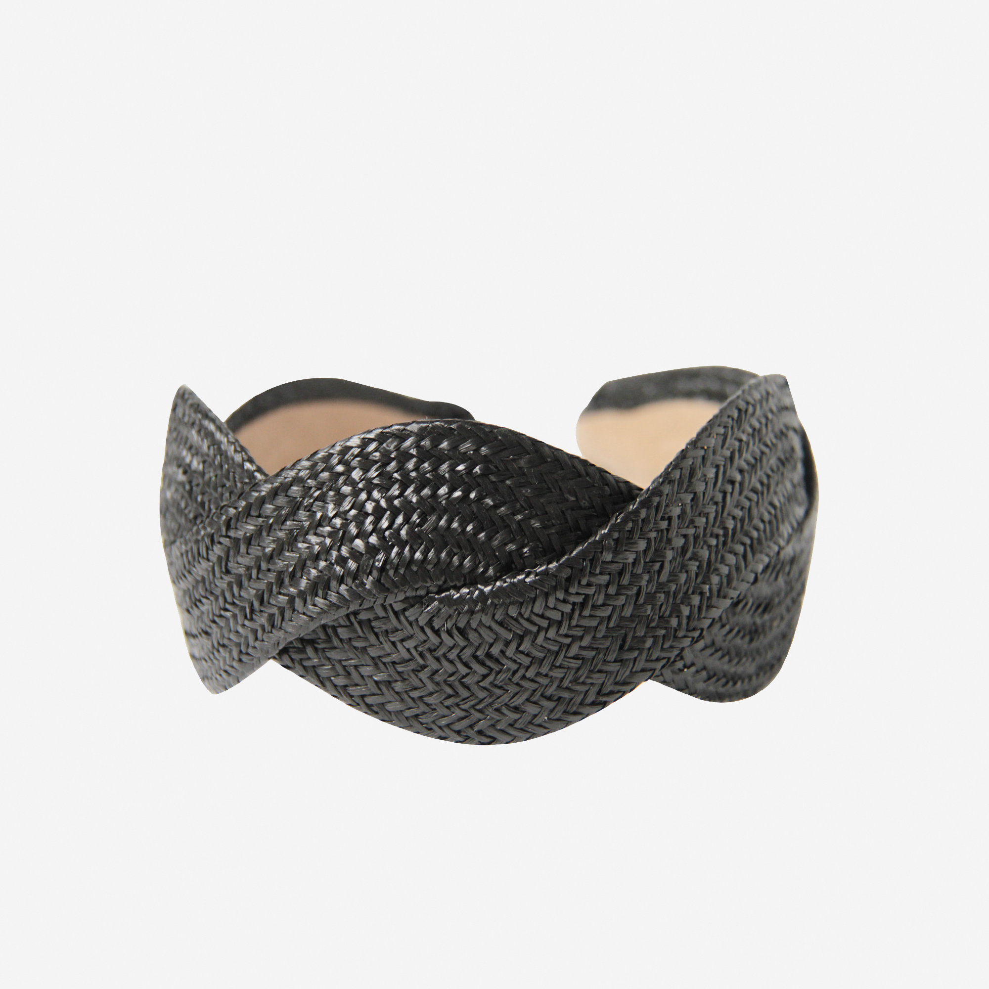 Woven black raffia headband on an off white background