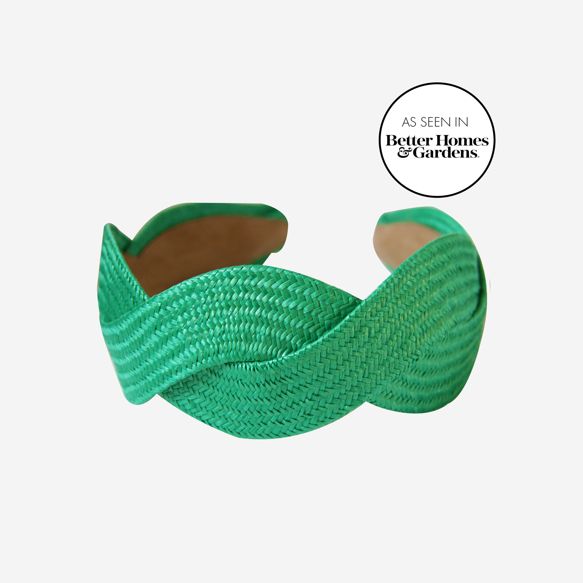 Woven green raffia headband on an off white background, with an as seen in Better Homes & Gardens stamp