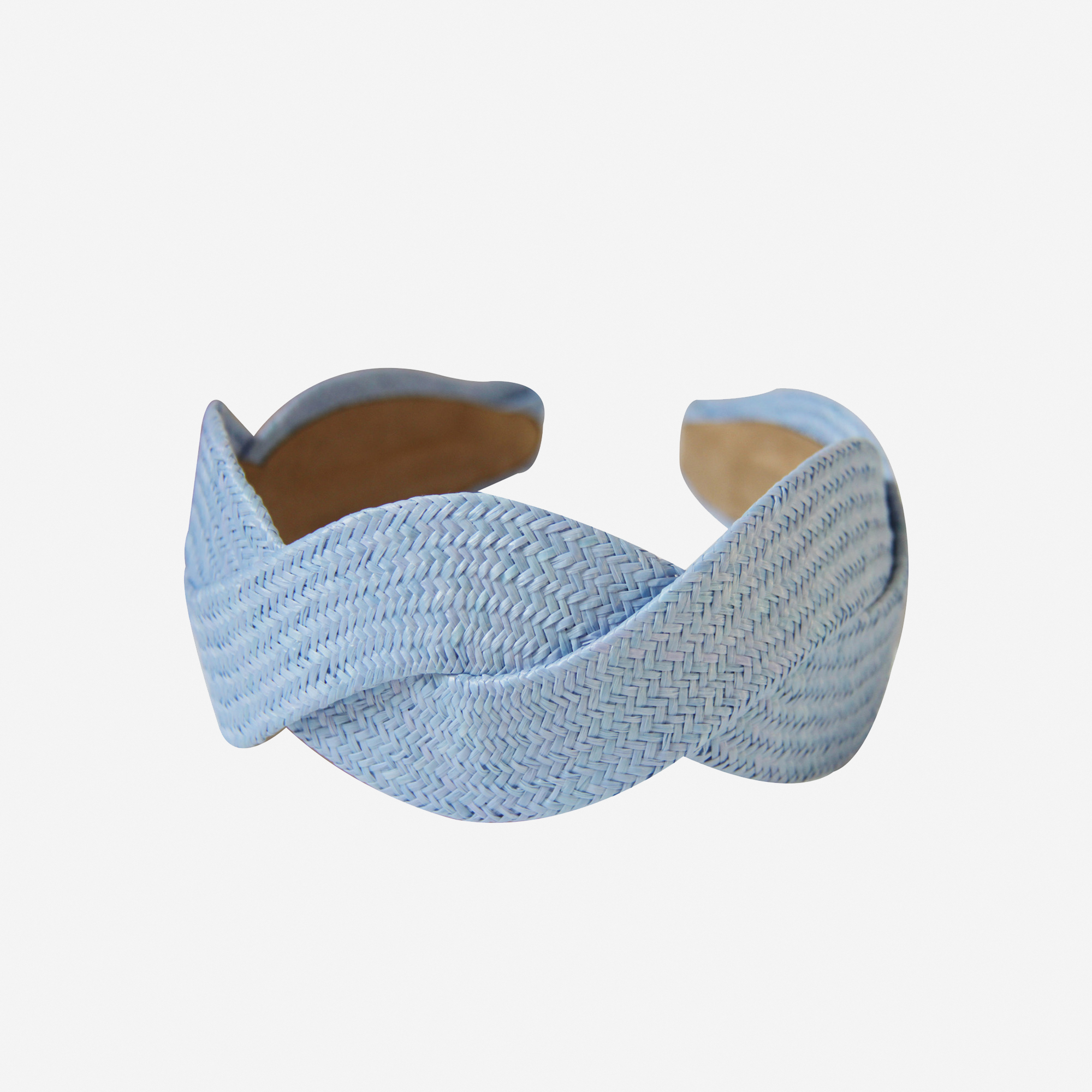 Woven light blue raffia headband on an off white background