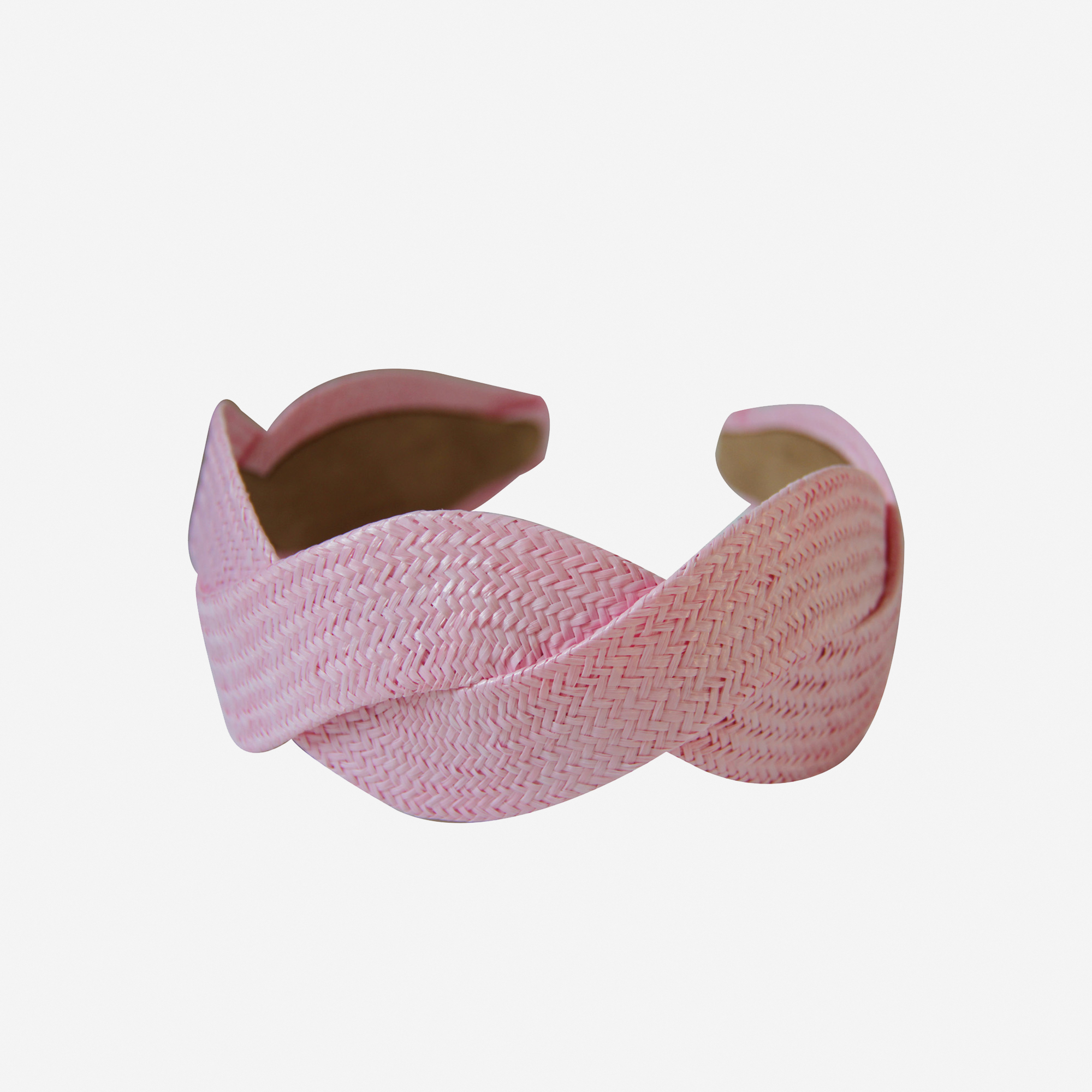 Woven light pink raffia headband on an off white background
