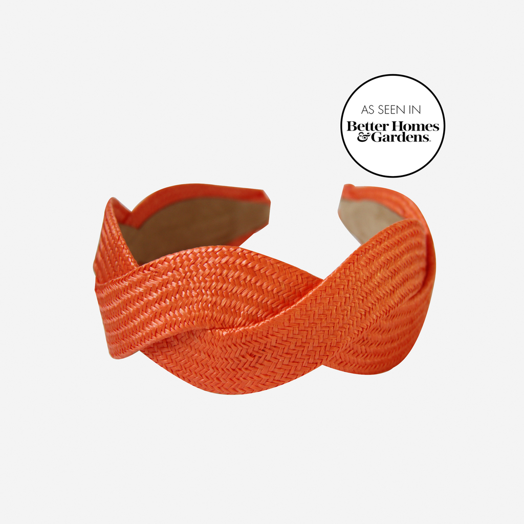 Woven orange raffia headband on an off white background, with an as seen in Better Homes & Gardens stamp