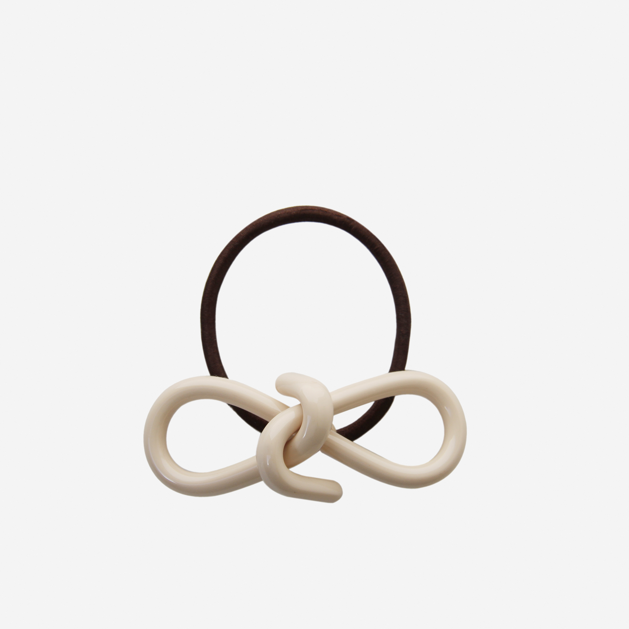Cream resin bow hair tie on an off white background