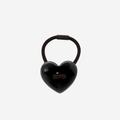 Black heart shaped resin hair tie on an off white background