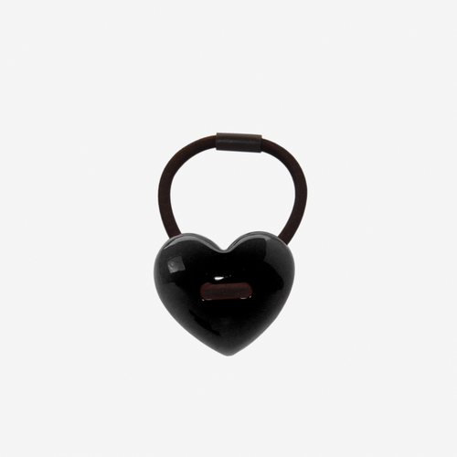 Black heart shaped resin hair tie on an off white background