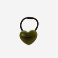 Green heart shaped resin hair tie on an off white background