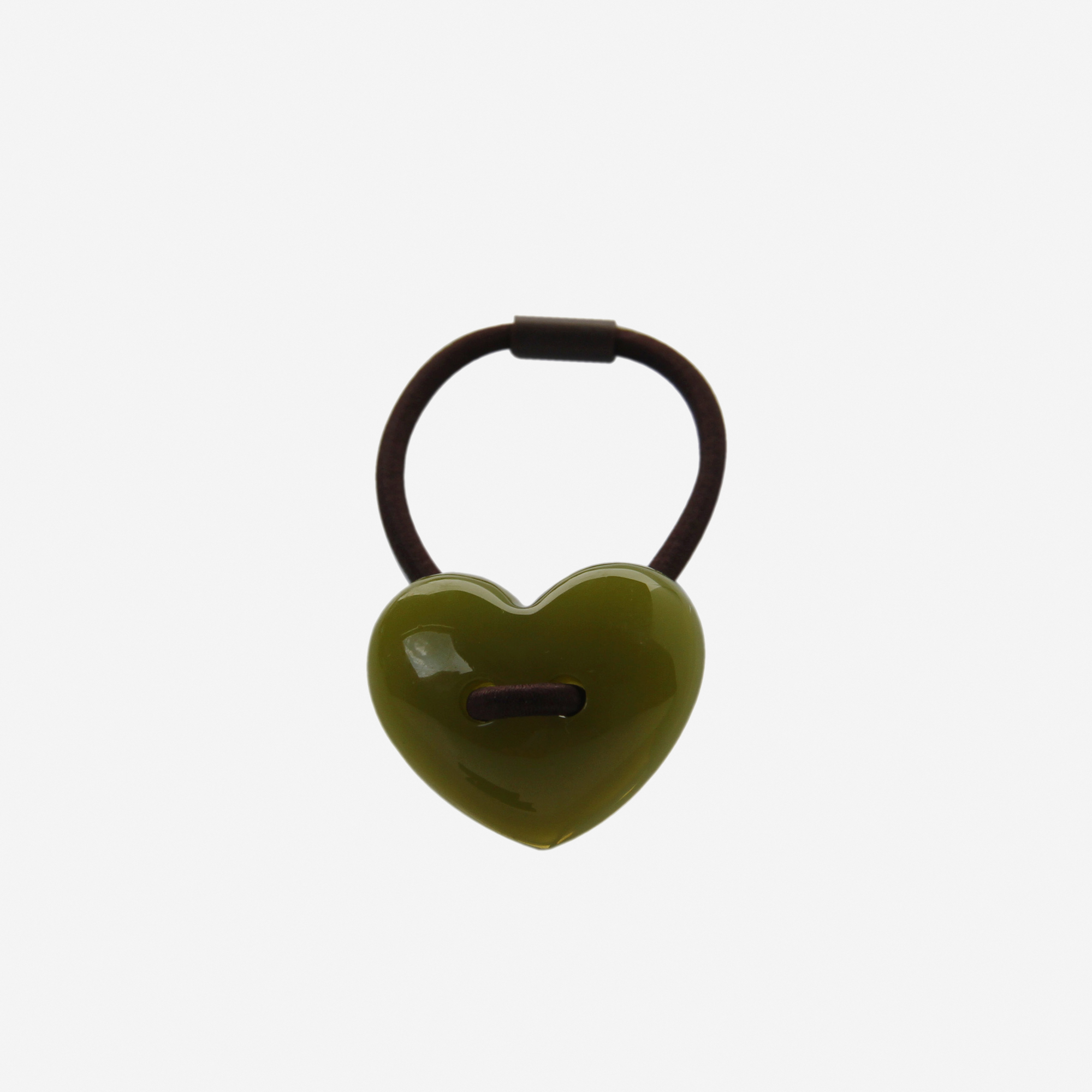 Green heart shaped resin hair tie on an off white background