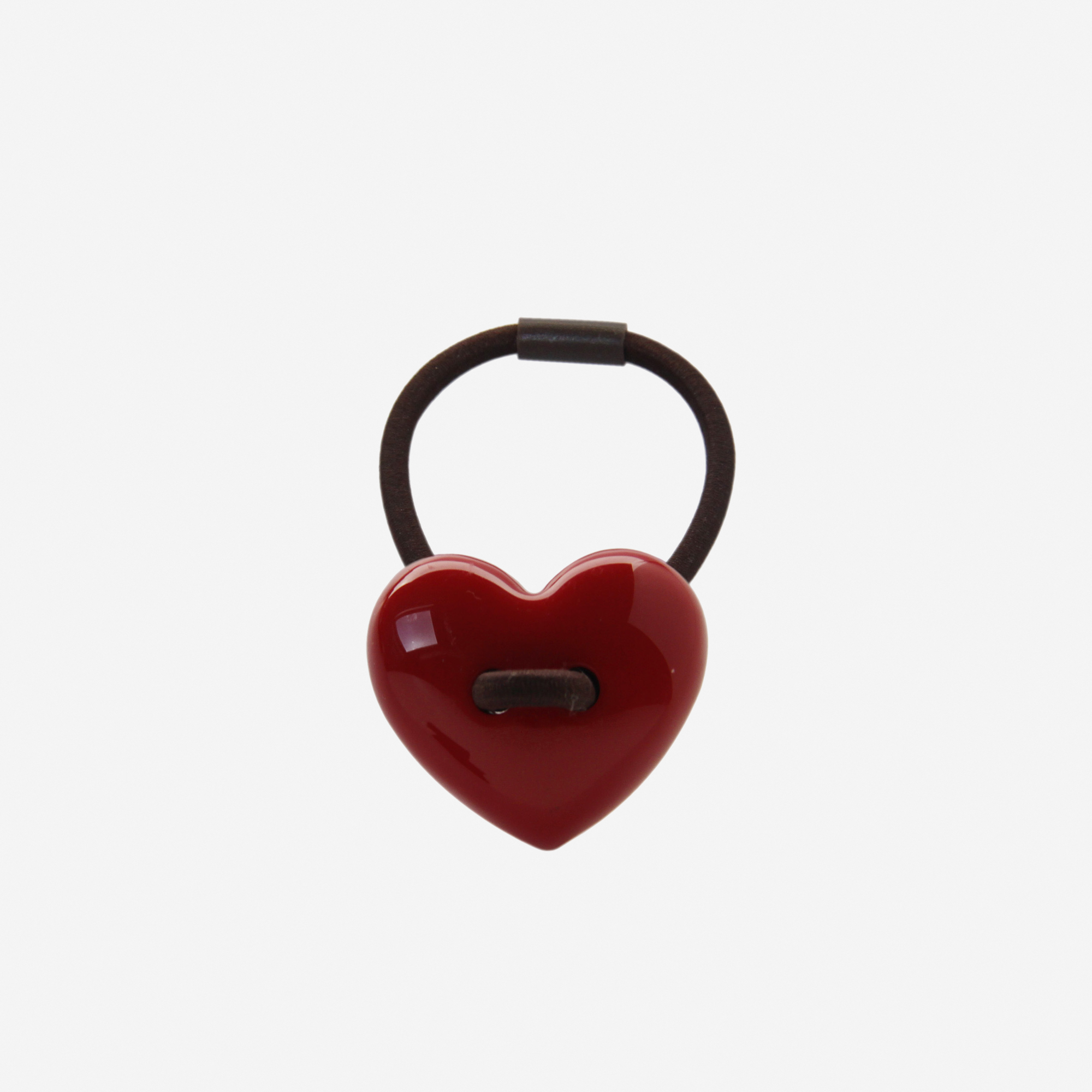 Red heart shaped resin hair tie on an off white background