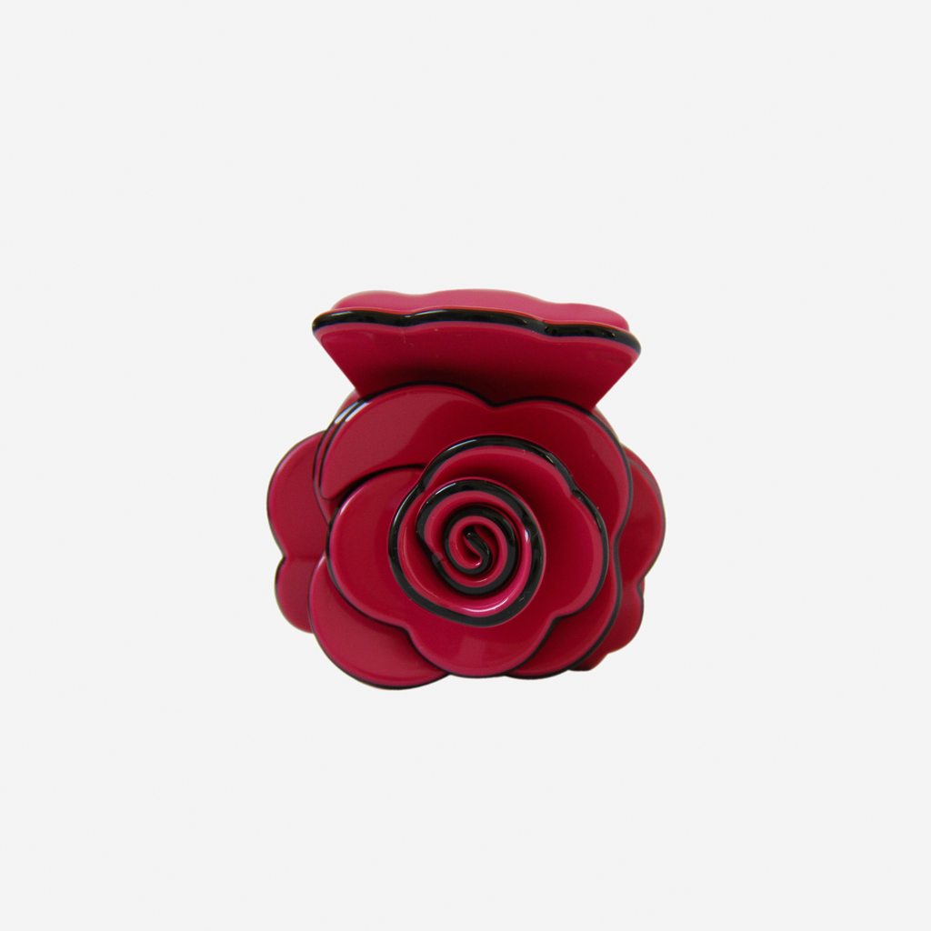 Crimson pink rose shaped hair claw on an off white background