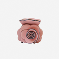Pink rose shaped hair claw on an off white background