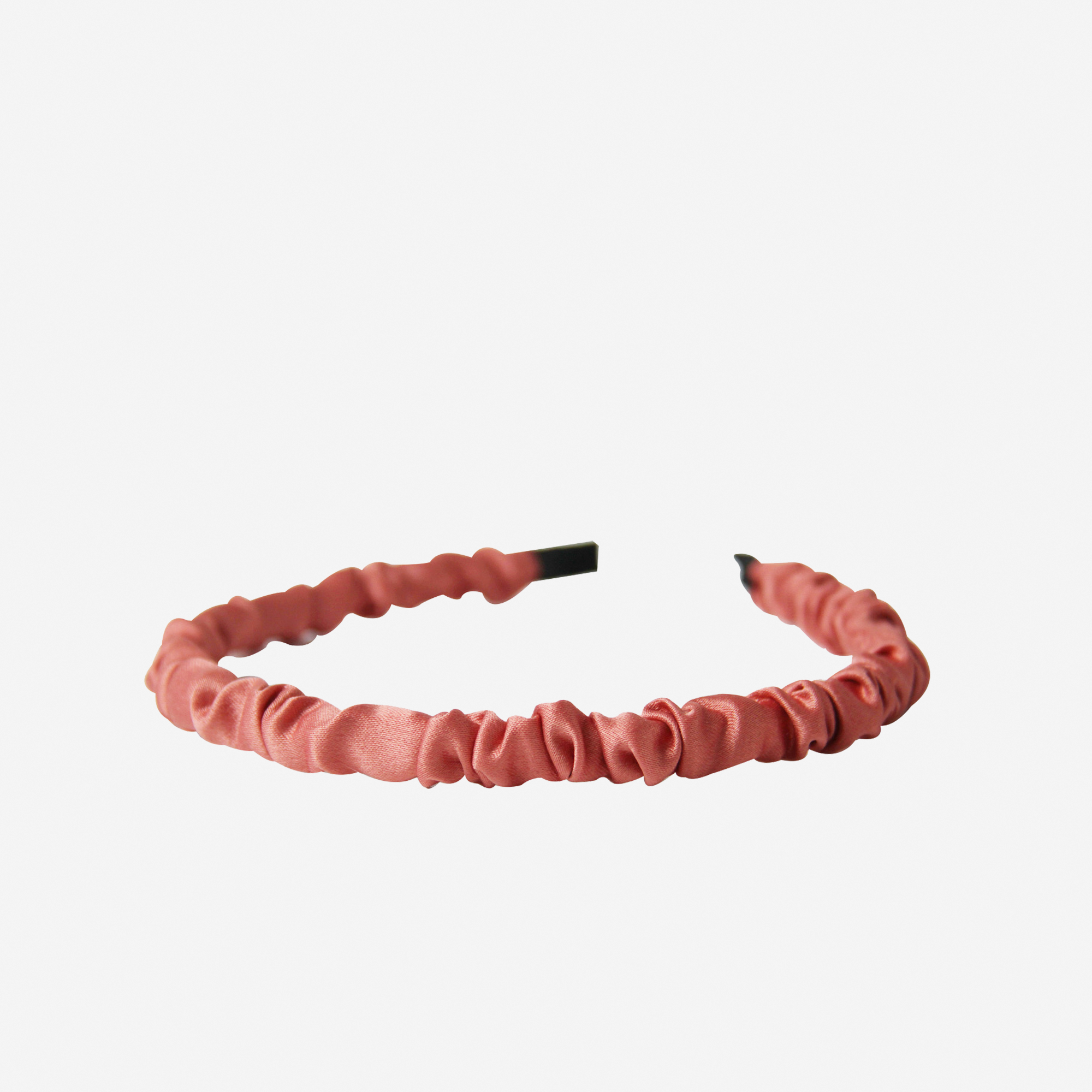Narrow ruffle ruched coral hairband on an off white background