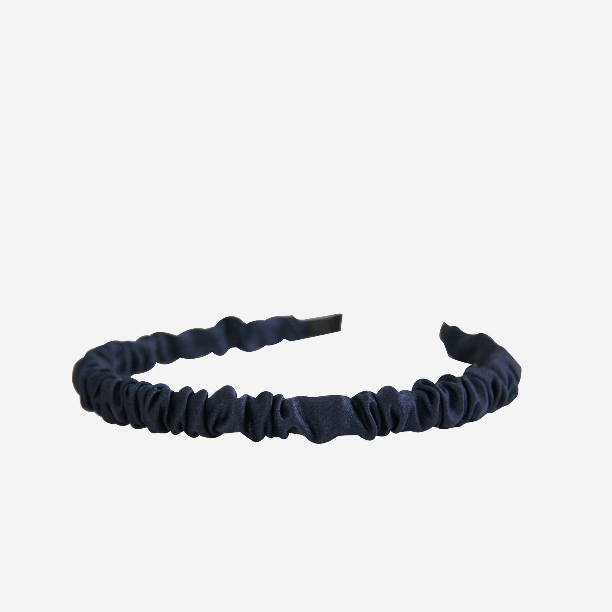 Narrow ruffle ruched navy blue hairband on an off white background