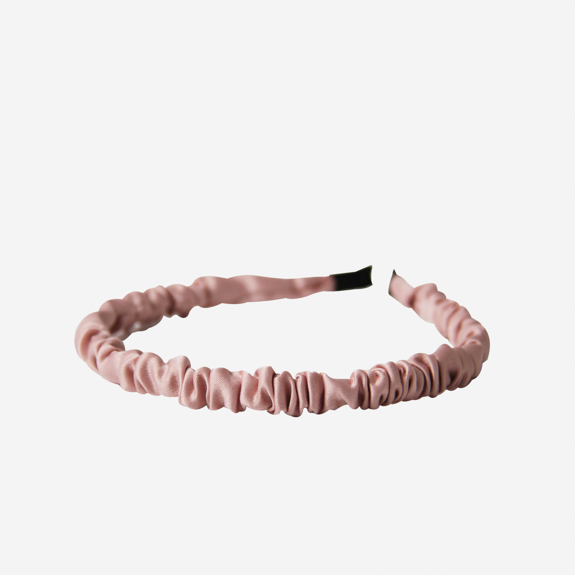 Narrow ruffle ruched pink hairband on an off white background