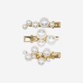 Set of 3 pearl and gold hair clips on an off white background, each hair clip features a cluster of pearls in a slightly different design