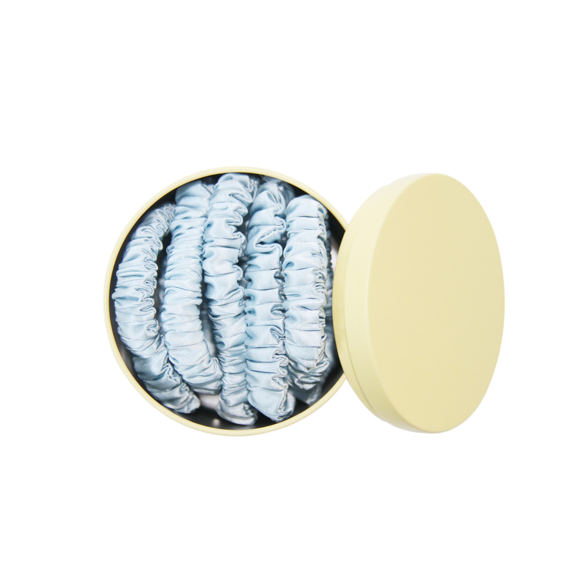 Set of 5 blue silk hair ties in a yellow tin on a white background