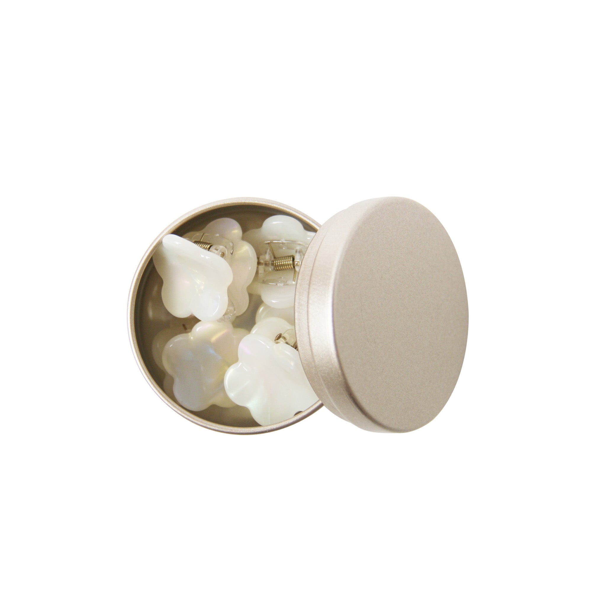 set of six mother of pearl resin hair claws in an open gold tin on a white background