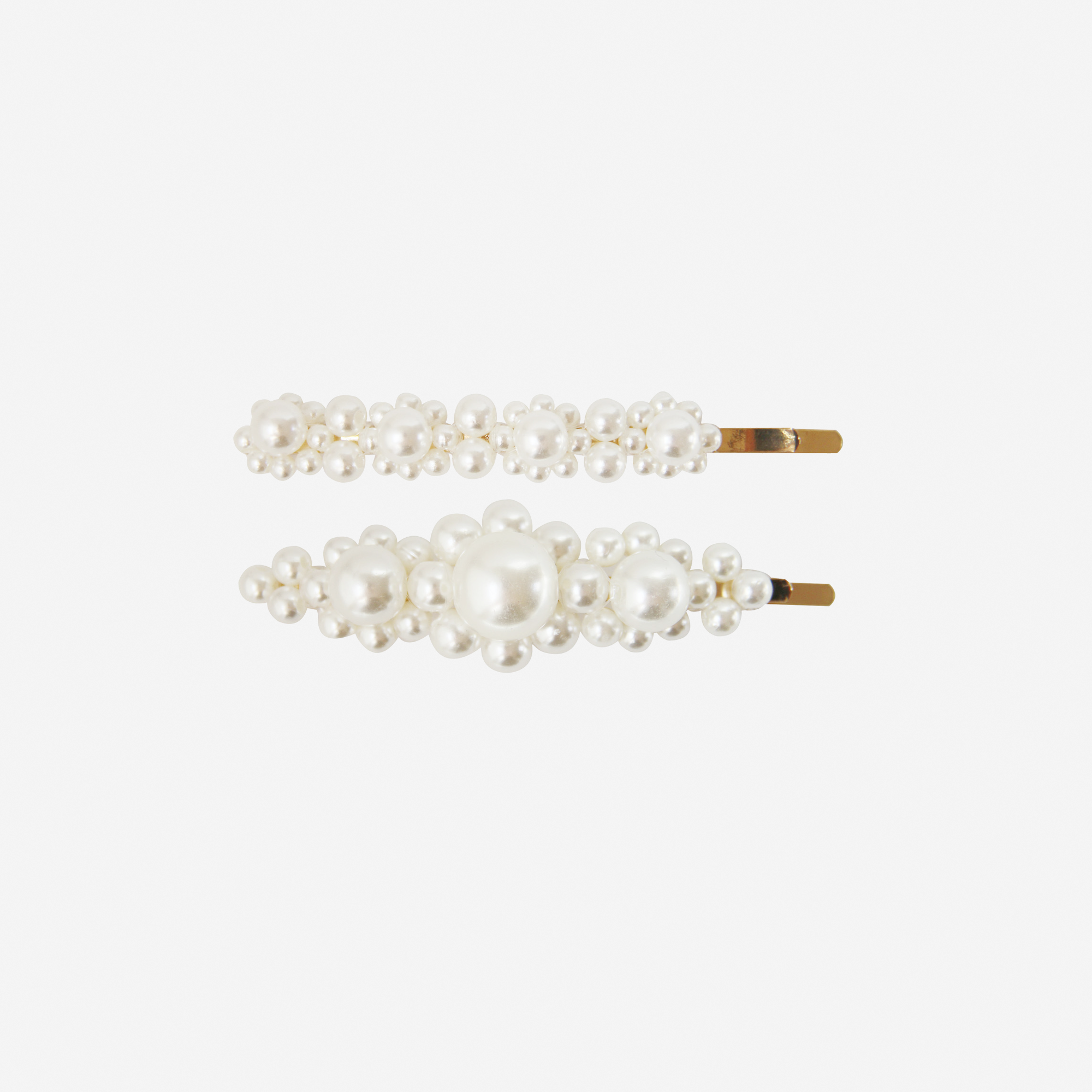 Set of 2 pearl and gold hair slides with lower designs on an off white background