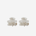 Set of 2 small mother of pearl hair claws on an off white background