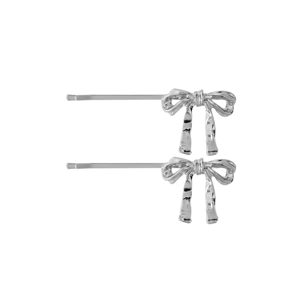 Set of two silver bow-shaped hair slides on a white background