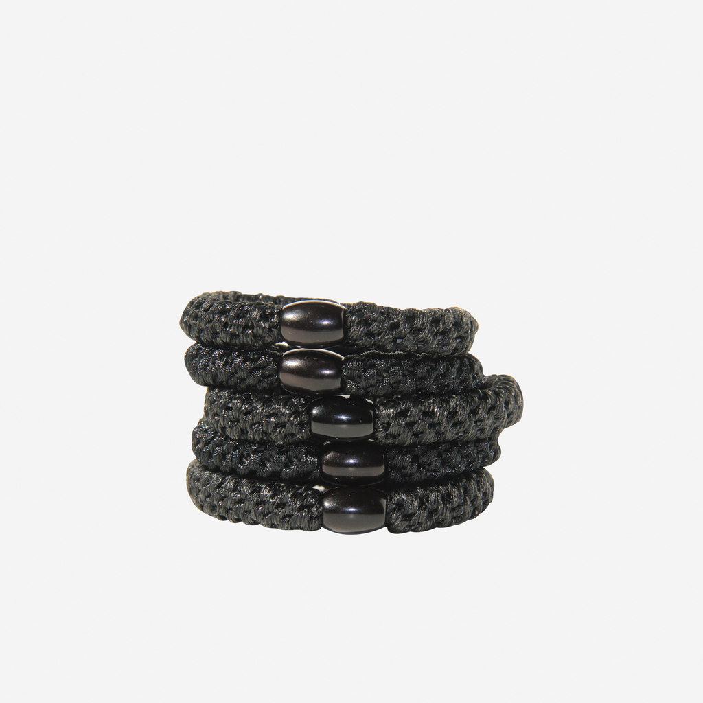 Set of 5 black hair ties, with a strong hold on an off white background