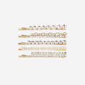 Set of 5 gold crystal hair slides, all 5 have a different design, on an off white background