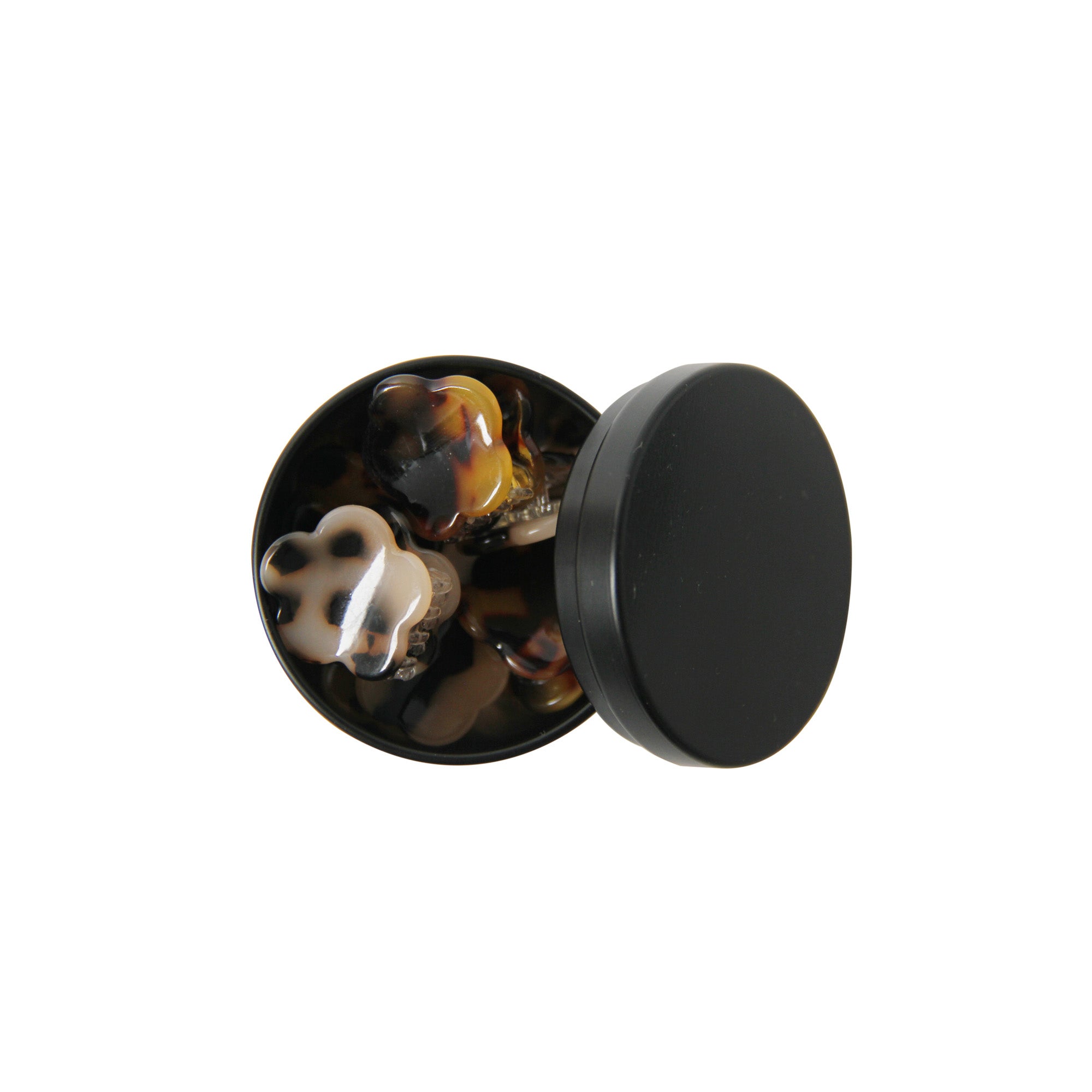 set of six tortoiseshell hair claws in a open black tin on a white background