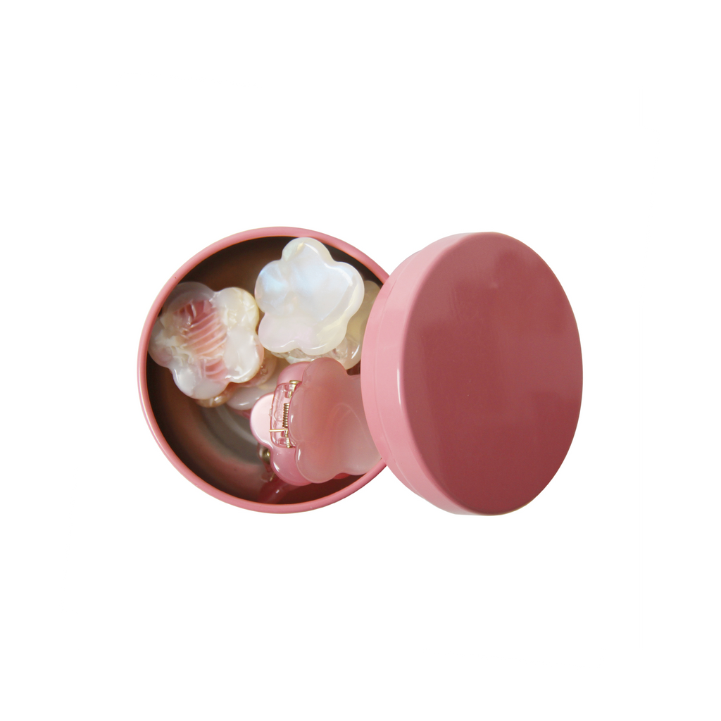 set of six pink hair claws in a open pink tin on a white background