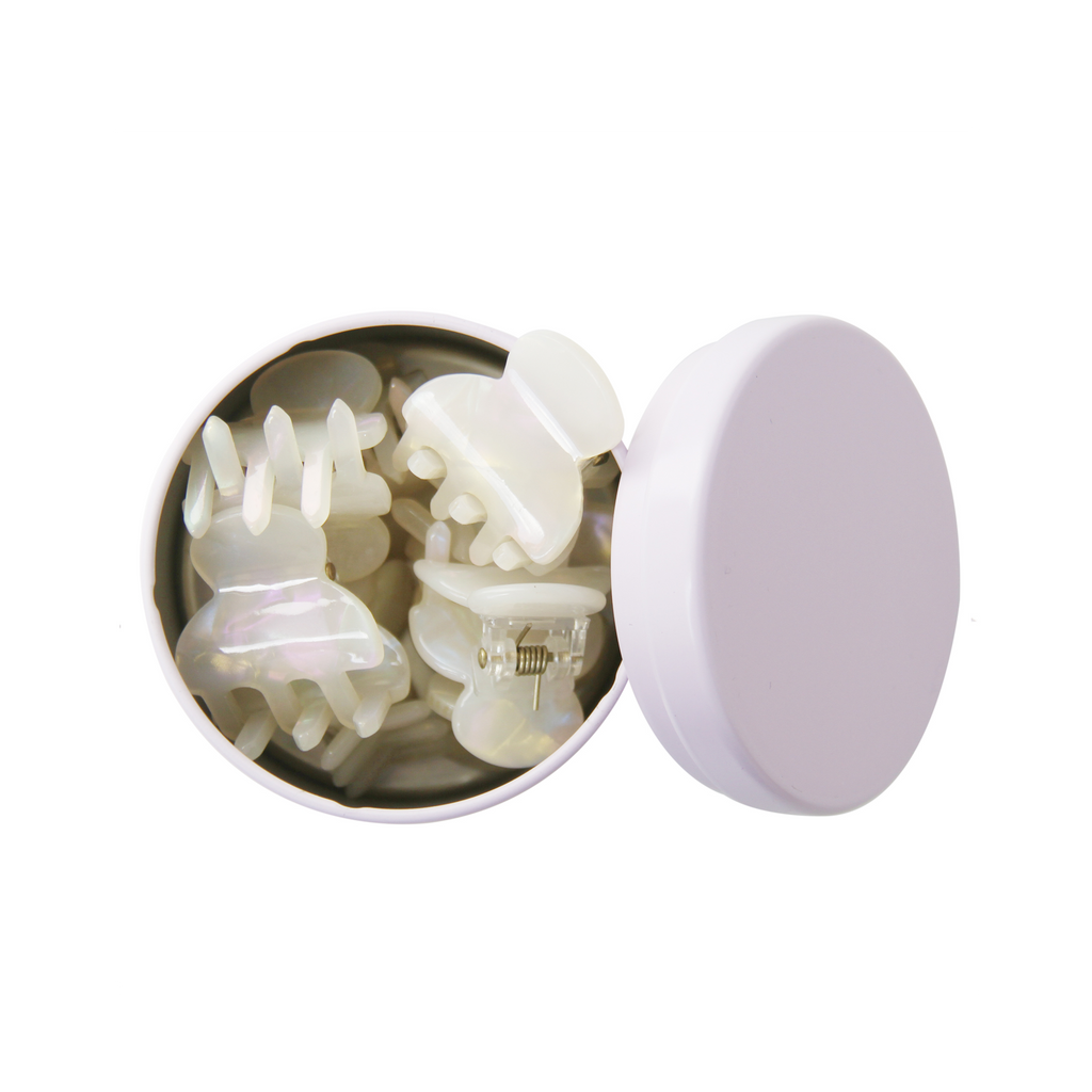 set of 8 mini pearlised resin hair claws in an open purple tin on a whitet background