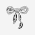 Statement silver bow hair barrette on an off white background