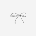 Silver bow hair clip on an off white background