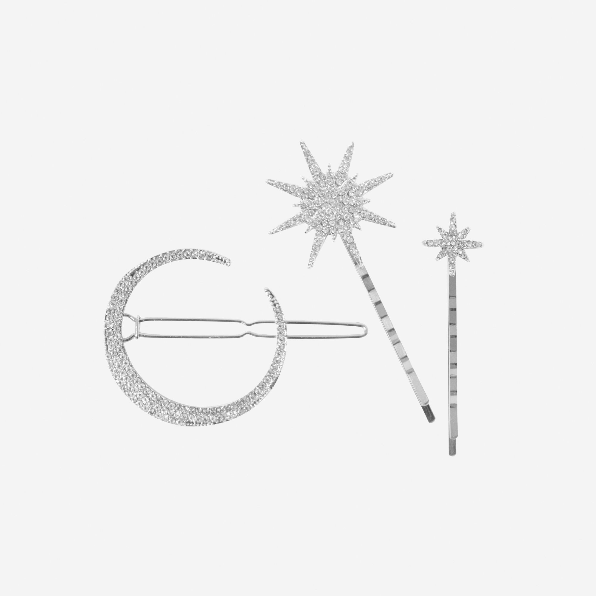 Set of 3 silver and crystal star and moon hair clips on an off white background