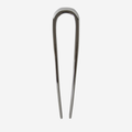 Silver metal french hair pin on an off white background