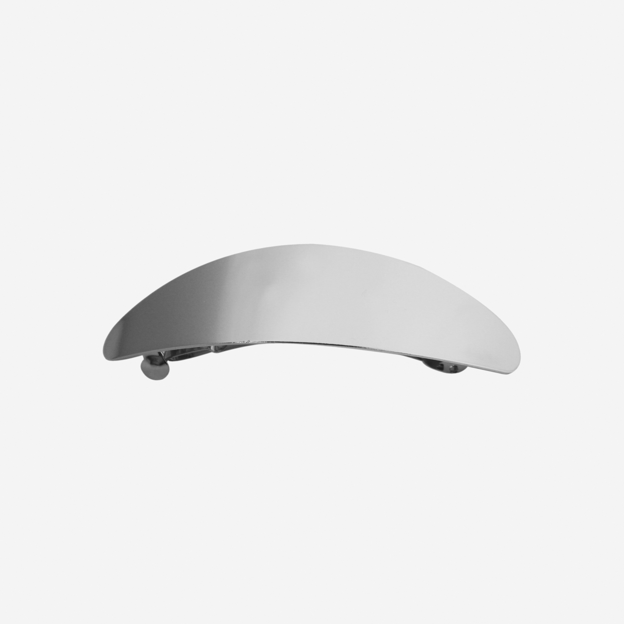 Oval silver slightly curved hair clip on an off white background
