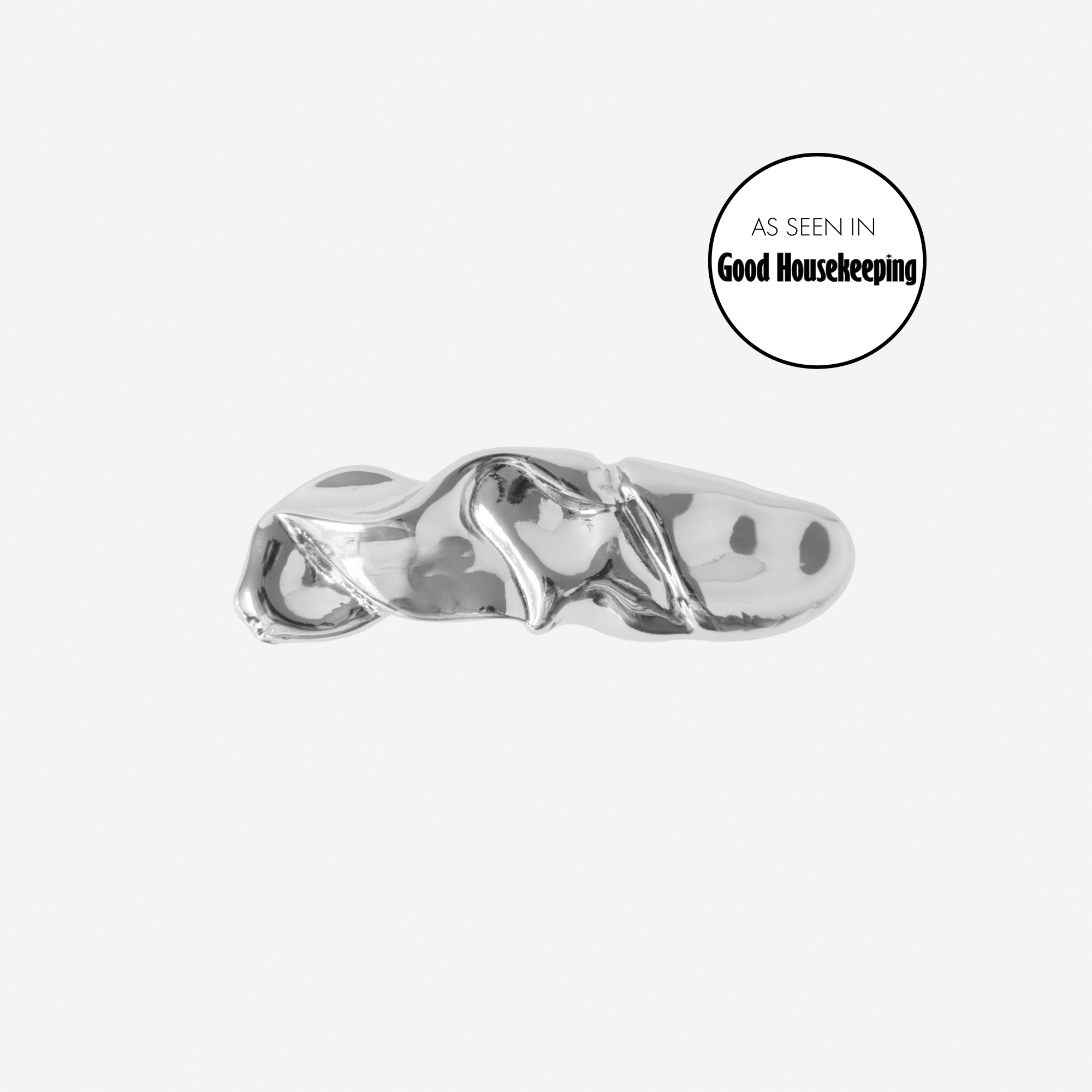 Silver folded hair clip featuring an as seen in Good Housekeeping logo, on an off white background