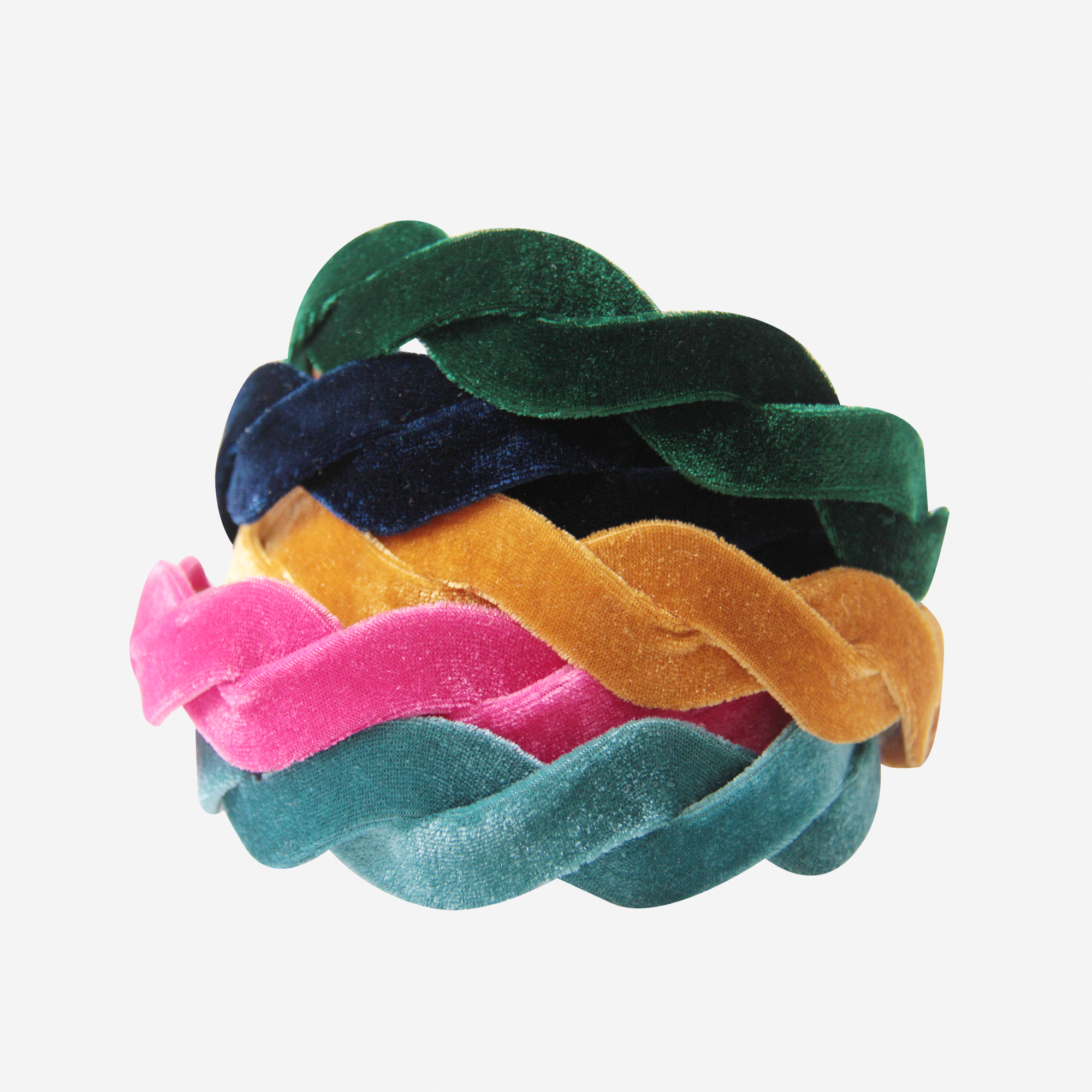 Stack of jewelled coloured velvet wave hairbands on an off white hairbands
