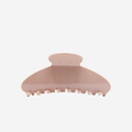 Blush pink oval hair claw on an off white background