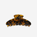 Dark Tortoiseshell oval hair claw on an off white background