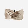 Gold twist headband on an off white background