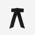 Black velvet hair bow on an off white background