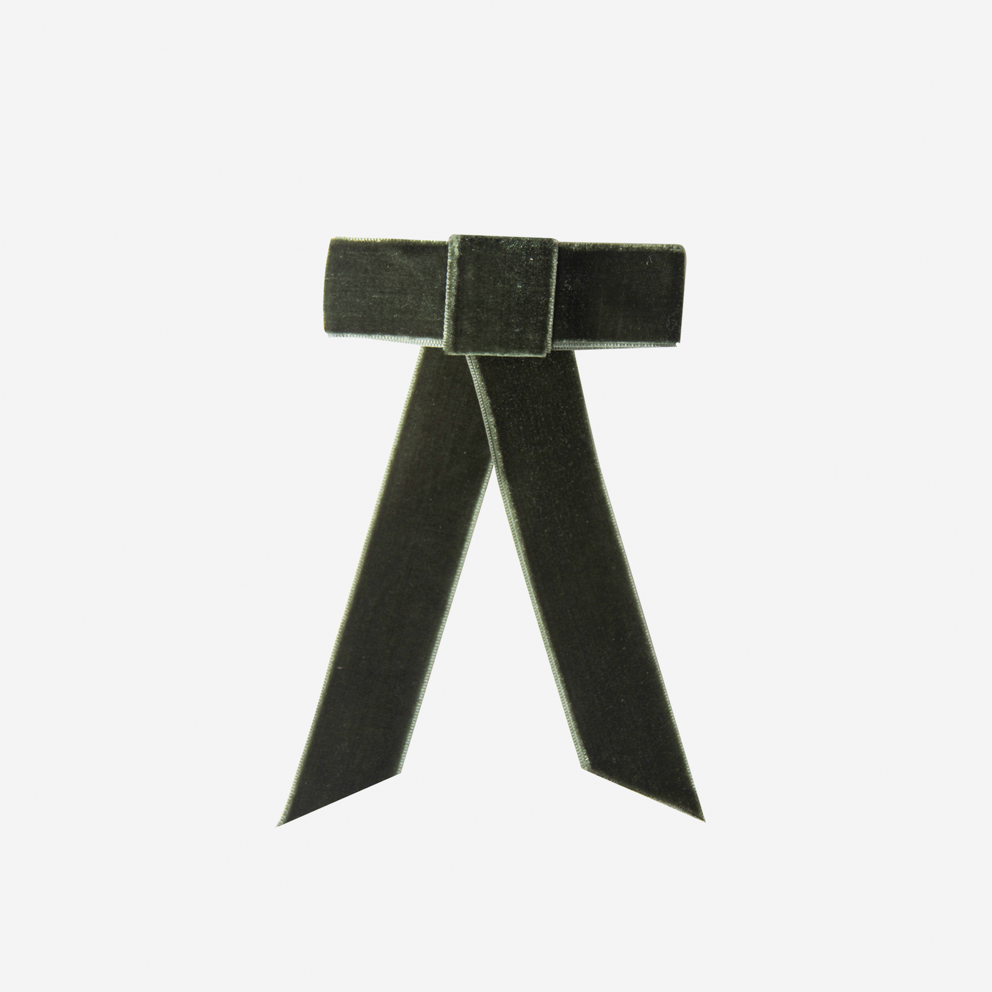 Green velvet hair bow on an off white background