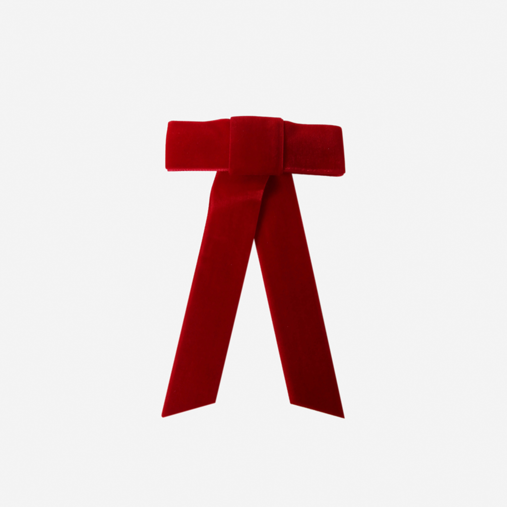Red velvet hair bow on an off white background